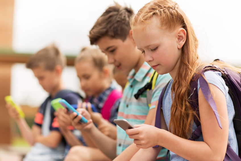 Kinder um Umgang mit Smartphones